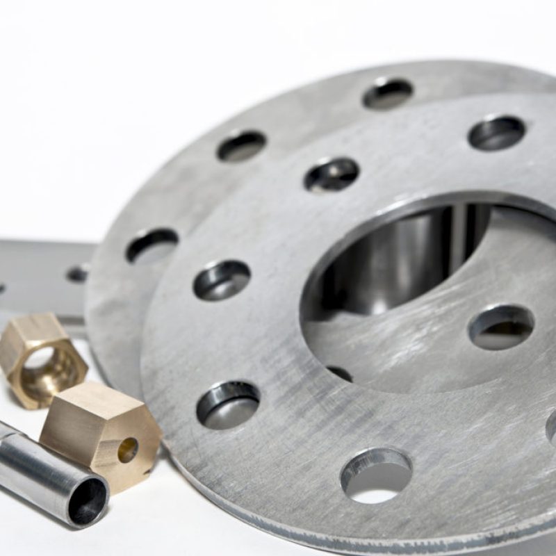 Closeup metal flanges and brass nuts. CNC milling and lathe industry.